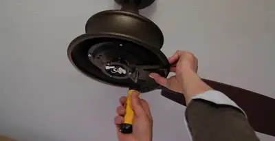 Electrician installing ceiling fan mounting bracket and fixture in Allentown, PA