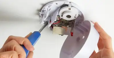 Certified technician wiring smoke detector during installation in Allentown, PA